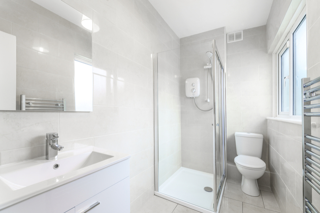 Small bathroom utilizing light colors and clear glass shower door to enlarge the space.