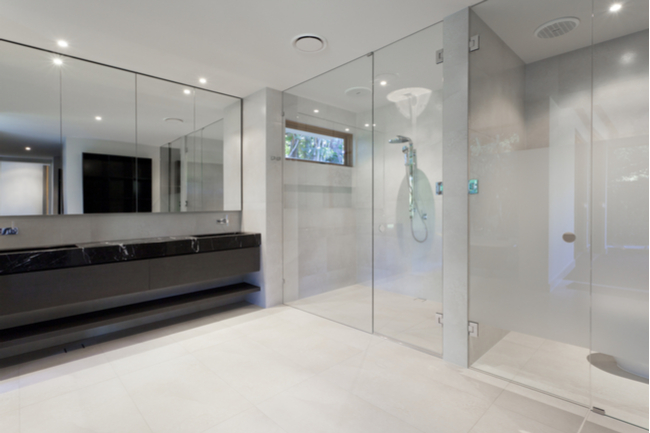 A shower enclosure with clear glass shower doors.