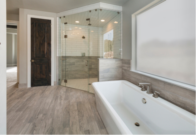 Neo angle glass shower door in a master bathroom.